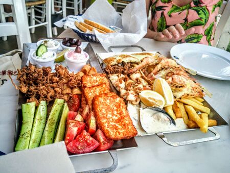 A plate of food on a table. Grilled shrimps or prawns served with lemon, garlic and sauce. Seafood. Top view. High quality photo. Food conceptの写真素材