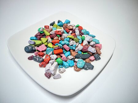 colored candy on the plate. Multi-colored stones candy on the plate, colorful stone texture background. Colored stones.の写真素材