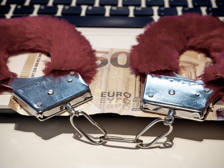 fluffy pink handcuffs on the computer. Love and Cyber Sex concept