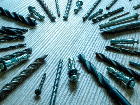 Old and used Round Shank Twist or Spiral Drill set. Selective focus. Instruments on a wooden table....