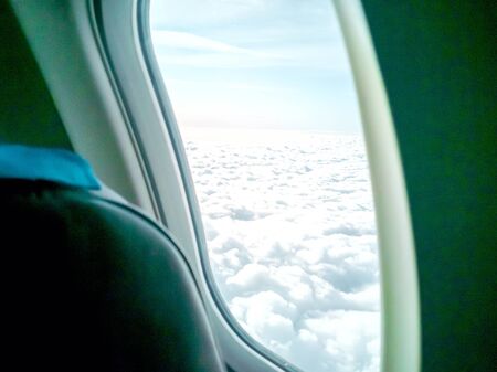 Clouds and sky as seen through window of an aircraft. Picture of plane in the blue sky panorama....