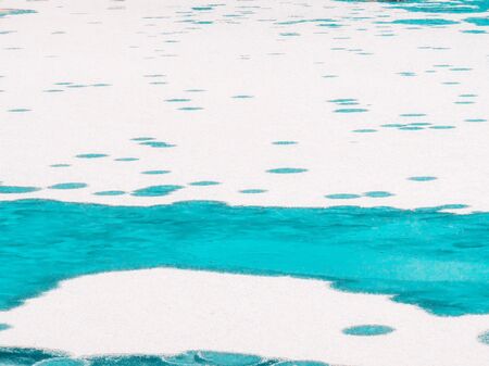 Winter white Landscape with ice and water circles. A frozen Manniku lake, snow texture close-up....
