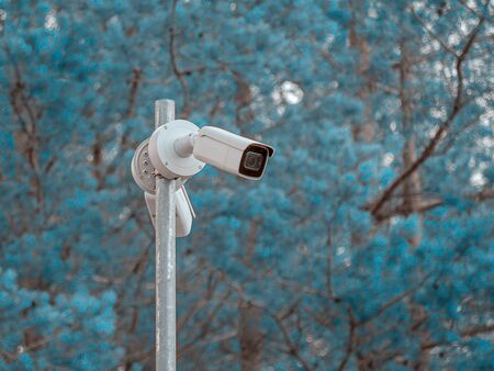 Security camera on the post. CCTV is Outside of a Building. Blue Sky on the background. Copy space...