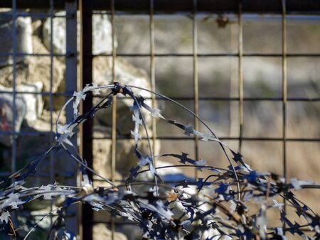 close up. Restricted Area Barbed Fence. Concrete wall, against the backdrop of barbed wire, the...