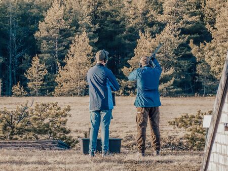 Men practicing of shooting outdoor. Shooting Center in Estonia, Tallinn. Forest on the background....