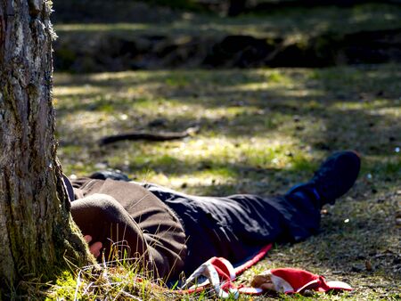 Worker makes a break in the garden. Lying in the Grass. vacation concept. hat over her headの写真素材