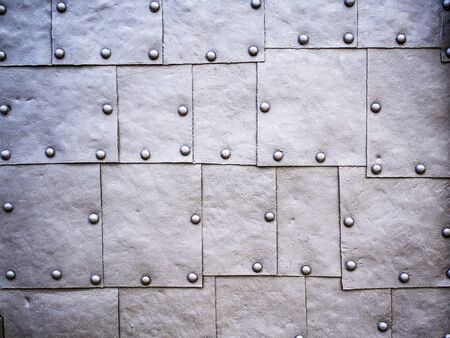 Old door fragment. Grunge metal background, steel plate texture. Metal plates assembled with rivetsの写真素材