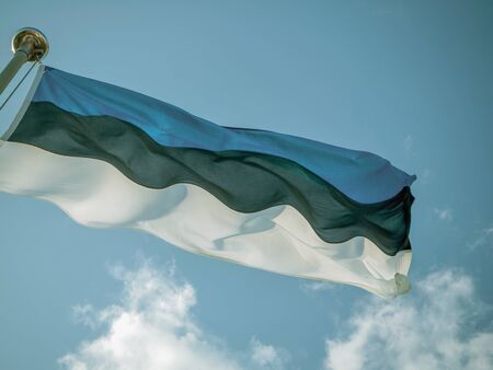 Estonian flag waving against blue sky. Copy space. Filtered imageの写真素材
