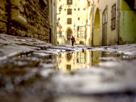 Selectife focus. Street And Old Town Architecture in Tallinn, Estonia. Old stone paved avenue street road. Cobble stones, low angle shot of wet old pavement. filtered or toned image. copy spaceの写真素材