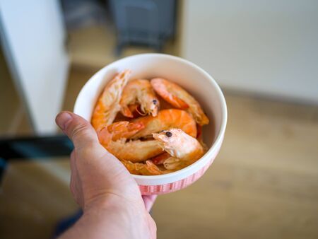  Bowl filled with fresh shrimps in man hands. Food for diet - Grilled shrimps with mango salad. Home cook in Asian kitchen.の写真素材