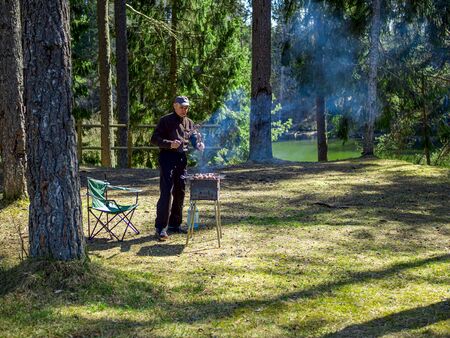 Red hot burning charcoal preparing for grilling, barbecue grill, BBQ. Forest on the background. Waiting for the placement of your food. Close up. vacation conceptの写真素材