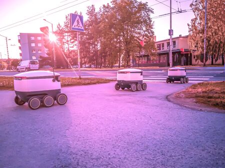 Some Delivery robots on the street. Estonian Cyber-couriers in Tallinn city. Sunny summer day. Copy space. Fitered image. the concept of new technology.の写真素材