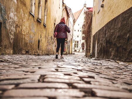 Selectife focus. Street And Old Town Architecture in Tallinn, Estonia. Old stone paved avenue street road. Cobble stones, low angle shot of wet old pavement. filtered or toned image. copy spaceの写真素材