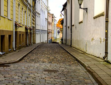 Selectife focus. Street And Old Town Architecture in Tallinn, Estonia. Old stone paved avenue street road. Cobble stones, low angle shot of wet old pavement. filtered or toned image. copy spaceの写真素材