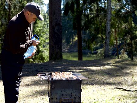 Red hot burning charcoal preparing for grilling, barbecue grill, BBQ. Forest on the background. Waiting for the placement of your food. Close up. vacation conceptの写真素材