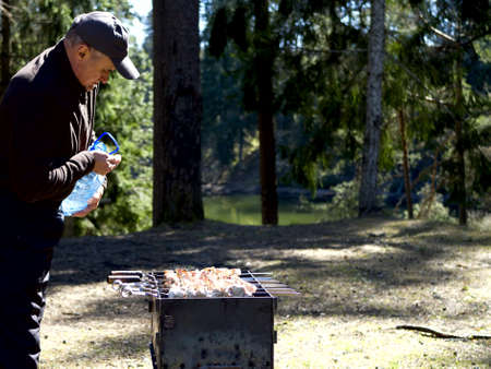 Red hot burning charcoal preparing for grilling, barbecue grill, BBQ. Forest on the background. Waiting for the placement of your food. Close up. vacation conceptの写真素材