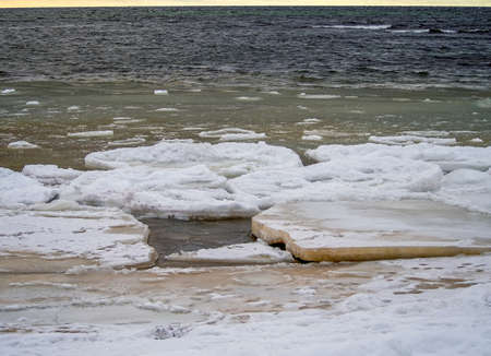 Trees a mountain pick, winter time. cliff on the coast of the Baltic sea. Suurupi in Estonia. Rocky Coasline. copy space. vacation and freedom concept. The view of big icicles and frozen waterの写真素材