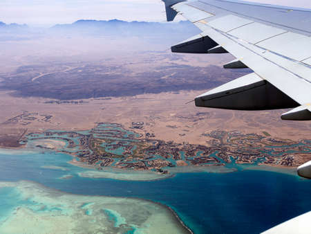 Aerial view above the clouds and sky, Inspiration concept. Travel freedom by air. Flight, view from the airplane to tropical sea with corals. Turbo-jet aircraft engine, transport 4k. Passenger airbusの写真素材