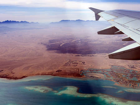 Aerial view above the clouds and sky, Inspiration concept. Travel freedom by air. Flight, view from the airplane to tropical sea with corals. Turbo-jet aircraft engine, transport 4k. Passenger airbusの写真素材