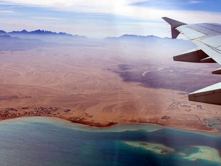 Aerial view above the clouds and sky, Inspiration concept. Travel freedom by air. Flight, view from the airplane to tropical sea with corals. Turbo-jet aircraft engine, transport 4k. Passenger airbusの写真素材