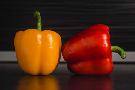 Two bell peppers red and orange on modern kitchen blurry backgroundの写真素材