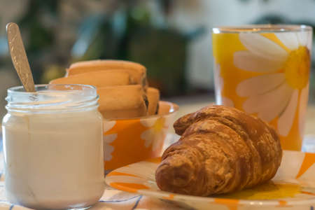 still life cup of tea, yogurt, muffins, cookies on blurred backgroundの写真素材