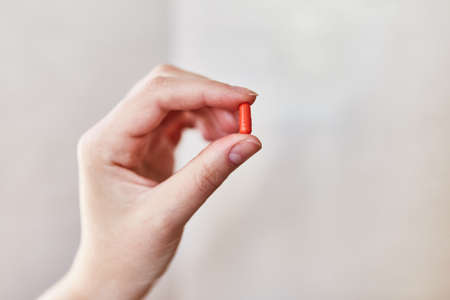 Girl holding a capsule in her hand.