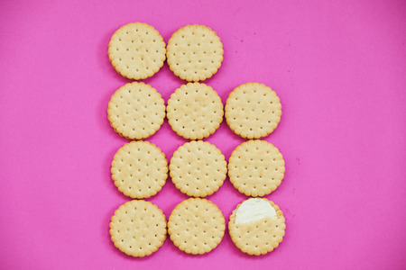 A number of brown biscuits on a lilac background. Close up.