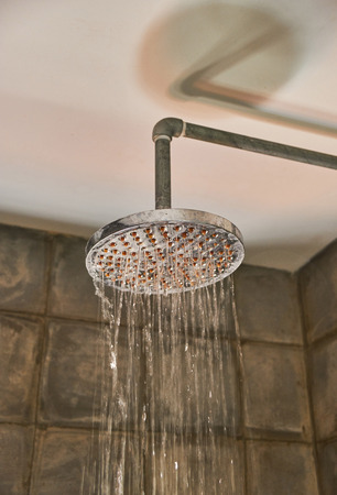 Running water of shower fauce. Shower in bathroom with water drops flowingの写真素材