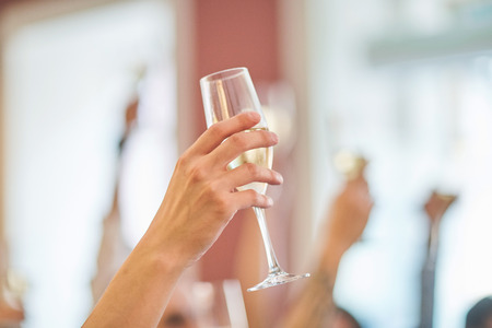 Glass of champagne on the background of friends at a party.