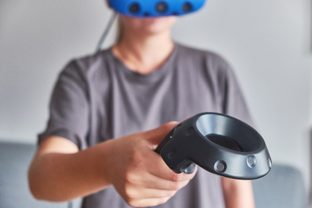 The girl in glasses of virtual reality with remote control in hand.