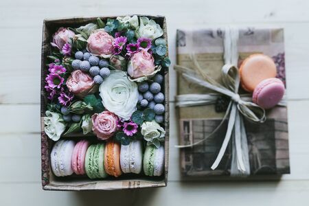 Colorful handmade macaroons in a gift box with flowers.の写真素材