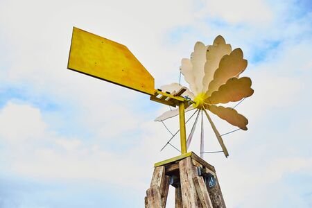 Old wooden windmill against a blue sky.の写真素材
