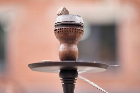 Bowl with coals. Dark glass hookah flask close up.