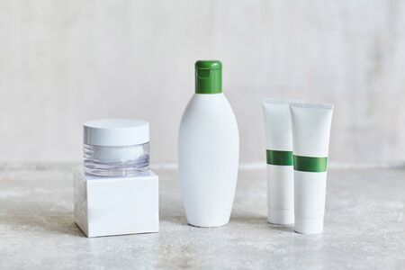Blank cosmetic containers on grey background. Skincare cosmetic products. Mockup