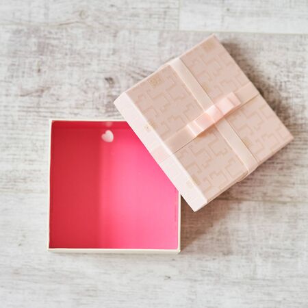 Pink gift box with a bow on a wooden background.の写真素材