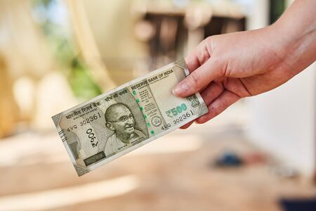 A Girl holds a new Indian 500 rupee banknote. Indian rupees. Indian moneyの写真素材