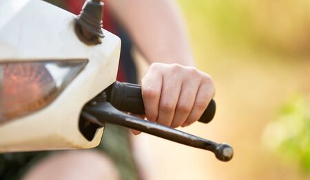 A girl in a green dress drives a scooter. A young girl rides a scooter.の写真素材