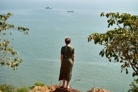 A young girl admiring the landscape. View from the back.の写真素材
