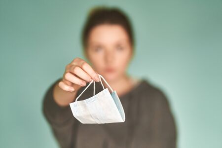 A Girl holds a medical mask in her hands.