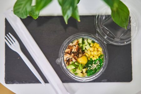 Rice with egg, avocado, cucumbers, corn in plastic packaging. Healthy breakfast.