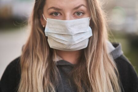 Girl in a medical mask on the background of the city. Coronavirus. Prevention of viral diseases.