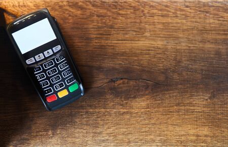 Bank pos terminal on a wooden background.