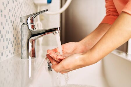 The girl washes her hands with soap to prevent coronavirus.