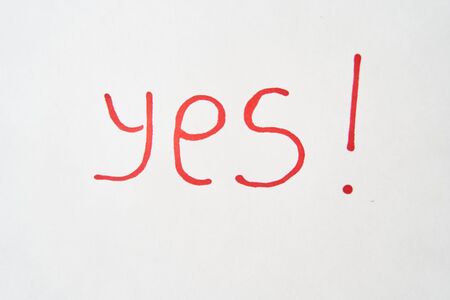 The inscription YES in red marker on a white sheetの写真素材