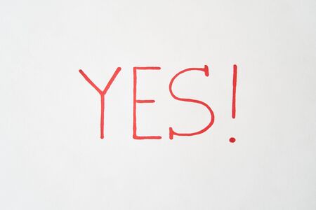 The inscription YES in red marker on a white sheetの写真素材