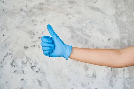a girl in a blue glove shows a sign like