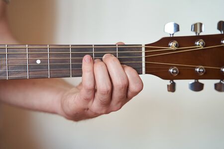 Musician Hand in Am Minor Chord on Acoustic Guitar