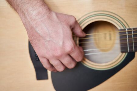 Musician Hand on Acoustic Guitar. Close up