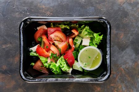 Diet salad with tomatoes and cucumbers and herbs. Healthy diet. Diet for weight loss. Healthy food delivery in plastic containersの写真素材